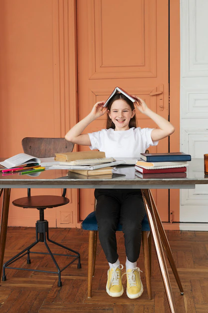 fille-souriante-plein-coup-assis-au-bureau